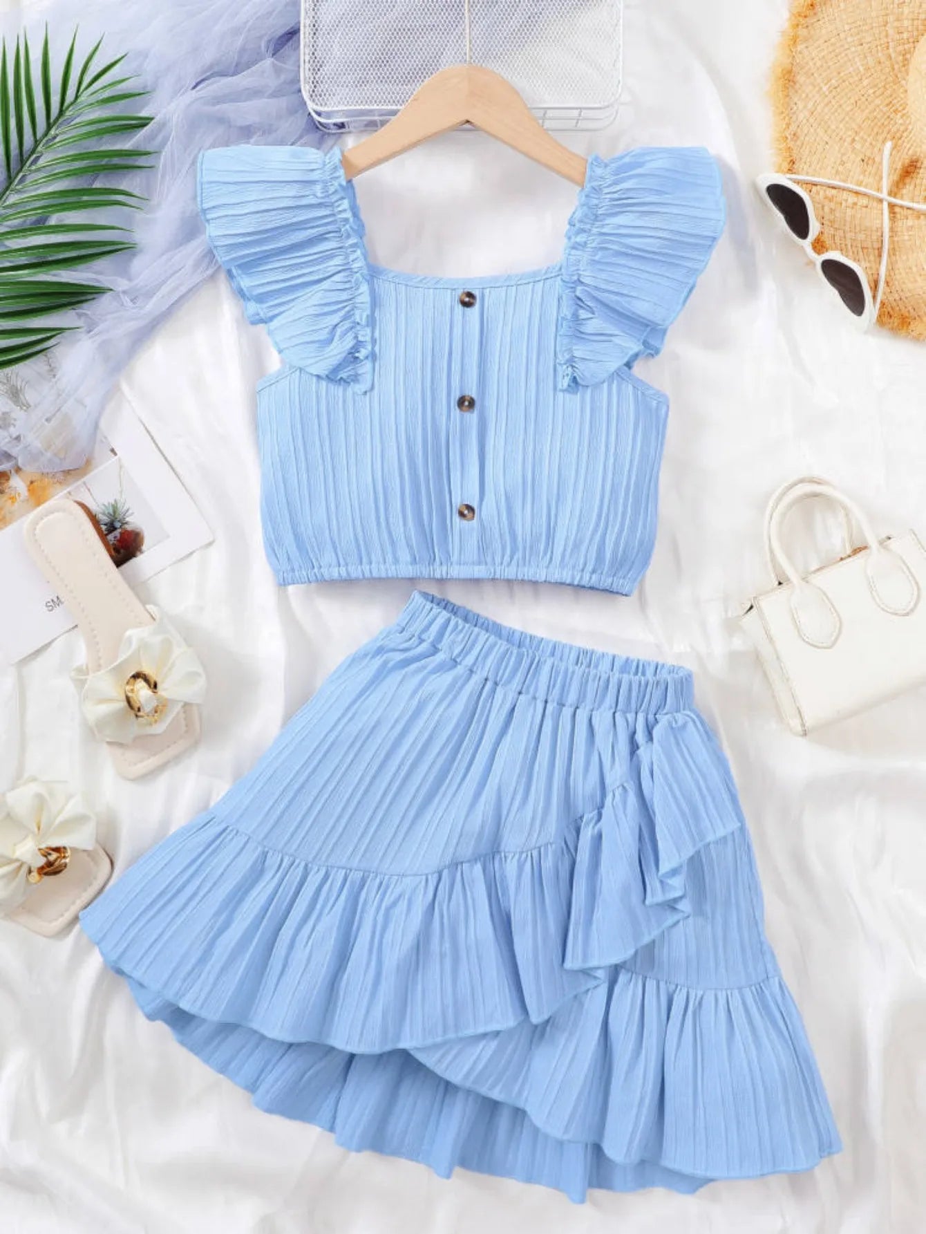 Girls’ Flutter Sleeve Crop Top and Skirt Set on Hanger
Blue Ruffle Skirt with Princess-Inspired Design
Girls Wearing Summer Party Outfit (8–12Y)